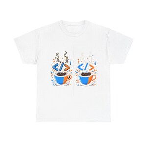 Può includere: T-shirt bianco con una grafica di due tazze di caffè, ciascuna con un design blu e arancione e vapore. Sopra ogni tazza ci sono simboli di codifica e il tag HTML. Il design è circondato da spruzzi blu e arancioni.