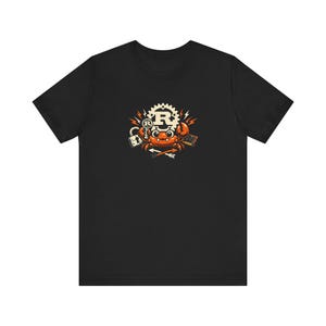 Puede incluir: Camiseta negra con un diseño de cangrejo de dibujos animados. El cangrejo naranja presenta la letra "R" en un engranaje. Otros gráficos incluyen un candado y una flecha. La camiseta está hecha de un material suave y cómodo.