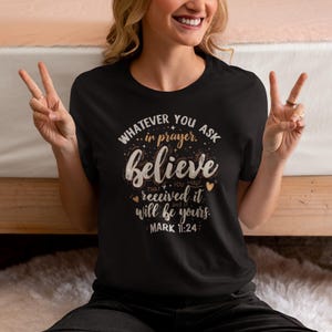 Puede incluir: Camiseta negra con el texto "WHATEVER YOU ASK in prayer. Believe THAT YOU HAVE received it and IT will be yours. MARK 11:24". La camiseta tiene cuello redondo y mangas cortas.
