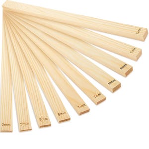 May include: A selection of light-coloured wooden strips, each marked with its width in millimetres. The strips vary in size from 3mm to 12mm. The wood grain is visible on each piece.