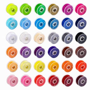 May include: A selection of sewing machine bobbins in a variety of colours, such as yellow, green, blue, pink, and brown. Each bobbin is filled with thread and has a clear plastic centre. The bobbins are arranged in a grid formation.