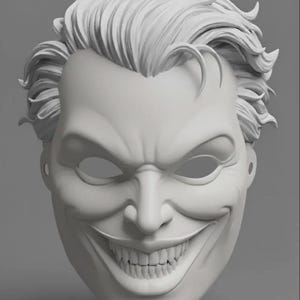 May include: A light gray, sculpted mask featuring a character with messy, swept-back hair, a wide, exaggerated grin showing teeth, and deep-set eyes. The mask has a smooth, matte finish and includes small circular holes on the sides for attachment.
