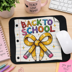 Może przedstawiać: Prostokątna czarna podkładka pod mysz z grafiką kartki w linię z napisem "BACK TO SCHOOL" wykonanym kolorowymi literami w stylu kredek oraz dużym żółtym ołówkiem zawiązanym w kokardę z różowymi gumkami i błyszczącymi gwiazdkami.