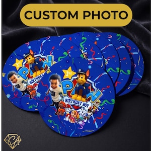 May include: A set of blue circular coasters featuring a "PAW Patrol" theme with a child's photo and the text "1st Birthday Boy". The coasters have colorful confetti and the words "CUSTOM PHOTO" in a gold oval.