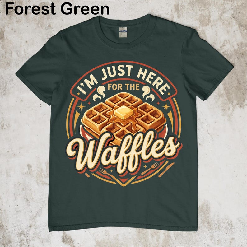 Puede incluir: Camiseta verde bosque con un dise&ntilde;o de gofres. El texto en el gr&aacute;fico dice "I'M JUST HERE FOR THE Waffles". Los gofres son dorados con mantequilla. Una camiseta divertida con tem&aacute;tica de comida.