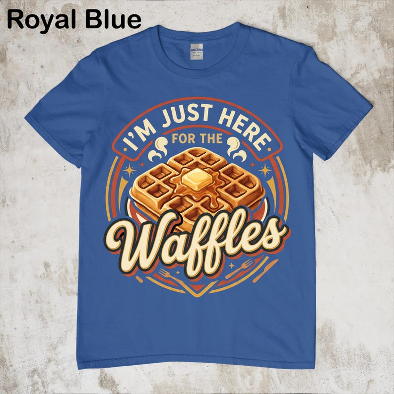 Puede incluir: Camiseta azul real con un gr&aacute;fico de gofres. El dise&ntilde;o presenta una pila de gofres con mantequilla y el texto "I'M JUST HERE FOR THE Waffles". El dise&ntilde;o incluye colores naranja, amarillo y marr&oacute;n.