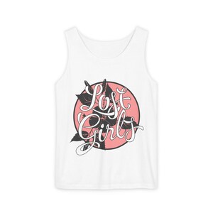 Op de afbeelding: Witte tanktop met een grafisch ontwerp. Het ontwerp toont de woorden "Lost Girls" in een cursief lettertype, tegen een roze cirkel met zwarte bloemaccenten. De tanktop is mouwloos.