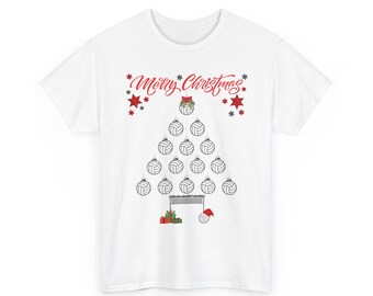 May include: A white short-sleeve t-shirt featuring a graphic of a Christmas tree made of volleyballs. The text Merry Christmas is printed in red above the tree. The design includes red stars, a volleyball net, wrapped gifts, and a Santa hat.