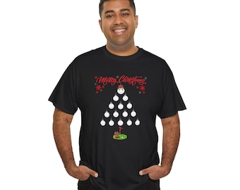 May include: A black short-sleeve t-shirt featuring a graphic of a Christmas tree formed by white golf balls. The text Merry Christmas is printed in red above the tree, and a small green golf putting green with a flag is at the base.
