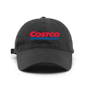 May include: A black baseball cap with the Costco Wholesale logo in red and blue. The hat has a curved brim and an adjustable strap at the back. The logo is centered on the front of the cap.
