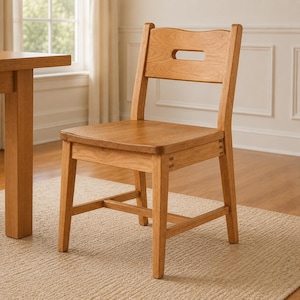 May include: A light brown wooden chair with a square seat and a backrest featuring a horizontal rectangular cutout. The chair has four straight legs connected by a lower support frame, showcasing visible joinery details on the side rails.