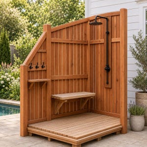 May include: An outdoor shower enclosure constructed from vertical cedar wood planks, featuring a black rainfall showerhead, a wall-mounted bench, and a side panel with three black hooks and a small shelf, all set on a slatted wooden floor base.