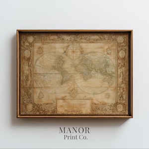 Op de afbeelding: Een ingelijste vintage wereldkaart print. De kaart toont gedetailleerde cartografie met continenten en oceanen in gedempte tinten. De lijst heeft een warme bruine kleur. De tekst "MANOR Print Co." staat onderaan de afbeelding.