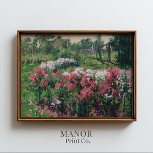 Pode incluir: Pintura de paisagem emoldurada com uma cena de jardim com flores rosa e brancas, folhagem verde exuberante e uma cerca de madeira. A obra de arte é assinada "MANOR Print Co."