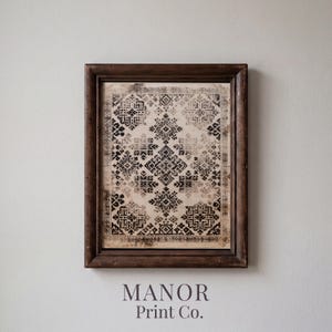 May include: A framed print featuring a repeating black geometric pattern on a beige background, enclosed in a dark brown wooden frame. The artwork displays intricate, symmetrical shapes arranged in a grid, with the text Manor Print Co. below.
