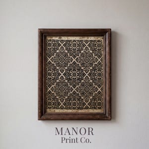 May include: A rectangular dark brown wooden frame containing a print with a repeating black and beige geometric pattern. The design features intricate, symmetrical, interlocking shapes. Below the frame, the text reads Manor Print Co.