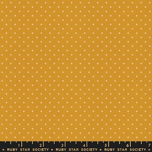 May include: Mustard yellow fabric featuring a repeating pattern of small white plus signs. The fabric has a textured appearance with subtle speckles. A ruler and the text "RUBY STAR SOCIETY" are at the bottom.