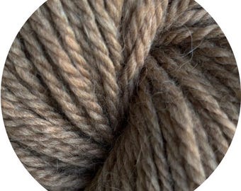 May include: Close-up of a ball of thick, textured yarn in shades of brown and tan. The yarn appears to be tightly spun, with visible strands creating a chunky, tactile appearance. Ideal for knitting or crocheting projects.