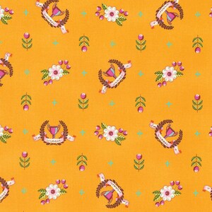 May include: A yellow fabric with a repeating pattern of pink flowers, green leaves, and brown wreaths with the text "I'm a winner" on a white ribbon.