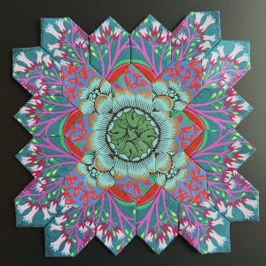 Peut inclure: Un bloc de patchwork carré composé de multiples pièces de tissu hexagonales. Le motif présente un centre floral vert entouré de couches de motifs botaniques bleu sarcelle, roses et orange avec des formes complexes en pétales.