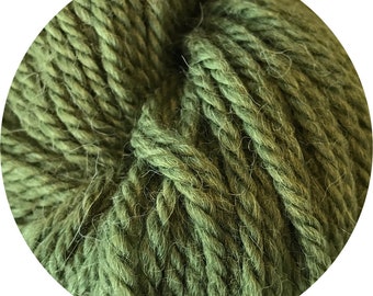 May include: A close-up of a skein of green yarn. The yarn is soft and fluffy, and it has a slightly textured surface.