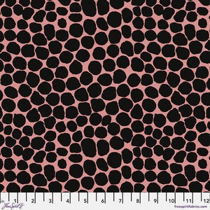 May include: A pink fabric with a black, irregular, polka dot pattern.