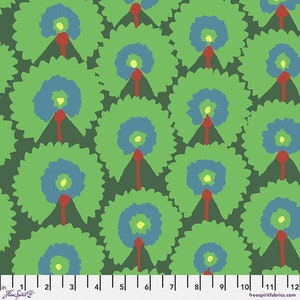 May include: Green fabric with a repeating pattern of blue and green circles with red accents. The fabric has a ruler with inches marked on it.