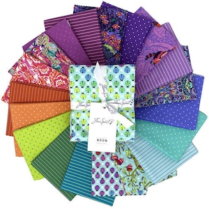 May include: A set of 16 fabric squares featuring a variety of colorful patterns, including floral, geometric, and polka dots. The fabric squares are arranged in a circle and are tied together with a ribbon. The ribbon has the text "Free Spirit" printed on it.