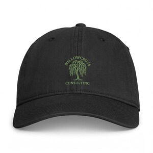 May include: A black baseball cap featuring an embroidered green willow tree graphic centered on the front panel. Above the tree, the text reads WILLOWCROSS in a curved arch, and below the tree, the word CONSULTING is embroidered in green.