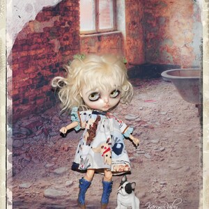 Könnte beinhalten: Eine Puppe mit blondem Haar, die ein gemustertes Kleid und blaue Stiefel trägt, steht neben einer kleinen weiß-schwarzen Hundefigur. Das Kleid zeigt Hundeillustrationen. Der Hintergrund zeigt eine zerfallene Backsteinmauer und ein Fenster.