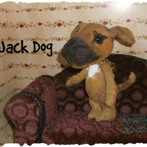 Puede incluir: Un perro de peluche marrón y blanco llamado "Jack Dog" sentado en un sofá marrón con un fondo de patrón floral.