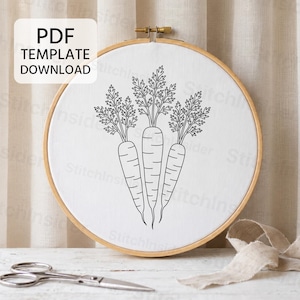 Pode incluir: Um bastidor de bordado redondo de madeira contendo tecido branco com uma ilustração de linhas pretas de três cenouras com folhas. Uma caixa branca no canto superior esquerdo contém o texto preto PDF TEMPLATE DOWNLOAD. Tesouras estão presentes.