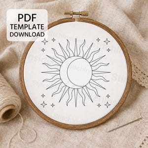 Puede incluir: Un bastidor de bordado circular de madera que contiene tela blanca con un diseño de líneas negras de un sol y una luna creciente rodeados de pequeñas estrellas de cuatro puntas. Un recuadro blanco muestra el texto PDF TEMPLATE DOWNLOAD.