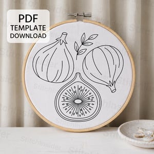 May include: A round wooden embroidery hoop containing white fabric with a black line art pattern of two whole figs, one halved fig, and a small leafy sprig. A white rectangular label in the top left corner displays the text PDF TEMPLATE DOWNLOAD.