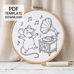 May include: A round wooden embroidery hoop containing white fabric with a black line art pattern of a mouse wearing a bow tie dancing next to a vintage gramophone with musical notes. The image includes the text PDF TEMPLATE DOWNLOAD.