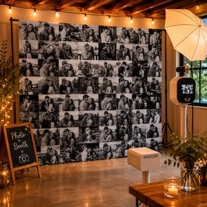 Könnte beinhalten: Ein Fotobox-Aufbau mit einem großen Hintergrund aus einem Raster von Schwarz-Weiß-Fotos, einem weißen Schirm-Diffusor, einer Fotokabinen-Säule und einem hölzernen Kreidetafel-Schild mit der Aufschrift Photo Booth und einem Kamera-Symbol.