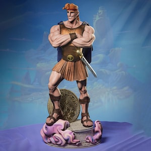 May include: A detailed figurine of Hercules, the Disney animated character, stands with arms crossed, wearing a brown tunic, skirt, and sandals. He holds a sword and stands on a decorative base with a shield. The figure has red hair and a confident expression.