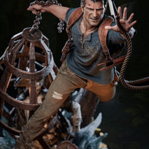 May include: A detailed action figure of a man in a blue shirt and brown pants, holding a chain and rope. The figure has a determined expression and is posed dynamically. The figure is 1-6 scale. The figure is available on Patreon.