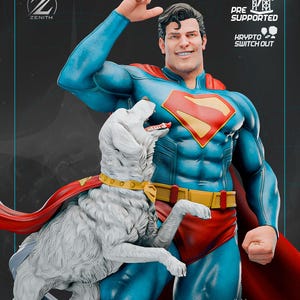 Puede incluir: Una estatua detallada de Superman con su icónico traje azul y rojo, con el emblema "S". Un perro blanco con capa roja está a su lado. La estatua presenta el texto "PRE SUPPORTED" y "KRYPTO SWITCH OUT".
