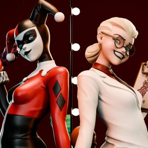 May include: Two Harley Quinn figures stand side-by-side against a dark red backdrop. One figure wears a red and black costume with a jester hat. The other figure is in a white lab coat and glasses, holding a clipboard. The figures are highly detailed.