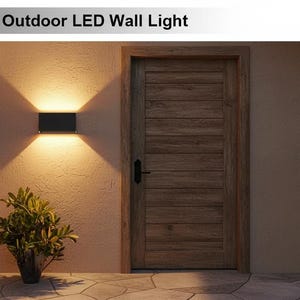 Pode incluir: Cena externa com uma luminária de parede LED preta em uma parede. O texto "Adjustable Outdoor LED Wall Light" está no topo. Uma porta de madeira e uma planta em vaso também são visíveis. A luz emite um brilho quente.