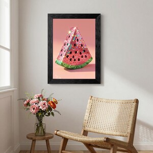 May include: A framed wall art print featuring a stylized watermelon slice covered in reflective pink, red, and green mosaic tiles. The artwork is encased in a simple black frame and displays a vibrant, sparkling surface texture against a solid pink background.