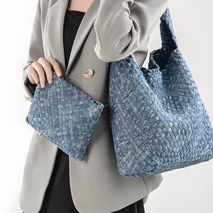 Puede incluir: Un bolso tote azul tejido y un clutch a juego. Las bolsas tienen un diseño texturizado de tejido de cesta. El bolso tote es grande y abierto, mientras que el clutch es rectangular.