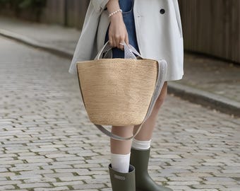 Handwoven straw bucket bag with an elegant one-shoulder drape