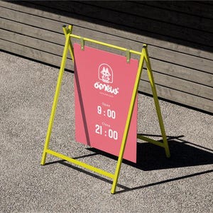 Könnte beinhalten: A-förmiges Werbeschild mit einem leuchtend gelben Rahmen und einem rosa Schild. Das Schild zeigt den Firmennamen und die Öffnungszeiten: 9:00 bis 21:00 Uhr. Das Schild steht auf einer grauen Oberfläche mit einem Holz Hintergrund.