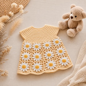 Puede incluir: Un vestido de ganchillo amarillo claro con cuello redondo y mangas cortas. La falda se compone de doce motivos cuadrados, cada uno con una margarita blanca con un centro amarillo brillante, dispuestos en cuadrícula con un borde festoneado.