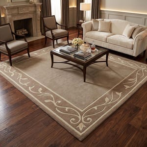 May include: A large rectangular area rug featuring a solid light brown centre and a darker brown border decorated with a cream-coloured scrolling vine and leaf pattern. The rug is positioned on a dark wood floor in a living room setting.