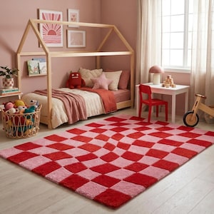 May include: A child's bedroom with a red and pink chequered rug. The room features a wooden house-shaped bed frame, a small red chair, and a white table. Decorative artwork and toys are also visible.