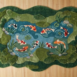 May include: A decorative rug featuring a pond scene with koi fish. The rug has a dark green border, with a blue pond area and colorful koi fish. The design includes water plants and rocks, creating a serene, nature-inspired aesthetic.