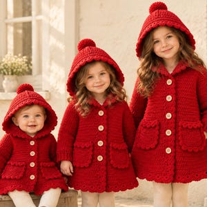 May include: Three matching bright red crochet coats with hoods, each featuring a pom-pom on top, scalloped edges, two front pockets, and light-coloured wooden buttons down the centre. The coats are designed in varying sizes to fit different ages.